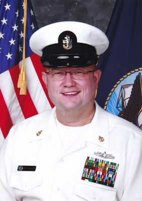 Formal Navy portrait with flags displayed in background