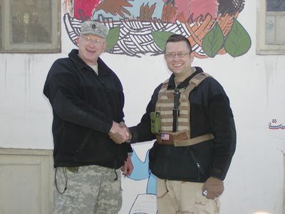 Handshake in front of a mural in Afghanistan