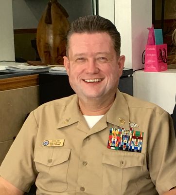 At home in uniform, tan service dress with ribbons