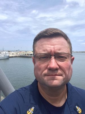 Harborside, naval vessel and dock in the background
