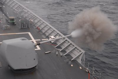 Naval 5-inch gun firing at sea during a training exercise