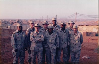 Forward-deployed team standing together at sunset in the field