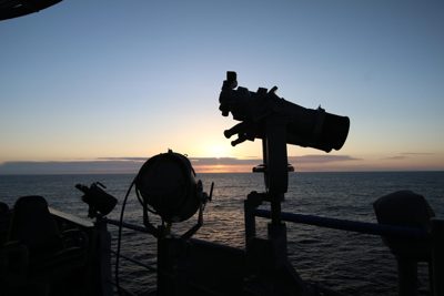 Watching the sea at golden hour with a telescope