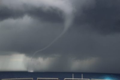 A waterspout building off the ship's bow at sea