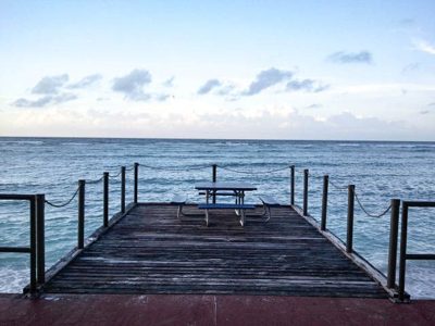 A long pier extending into calm water during a quiet moment between watches