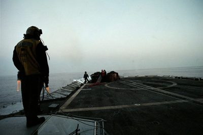 A Sailor standing watch as fog rolls across the flight deck