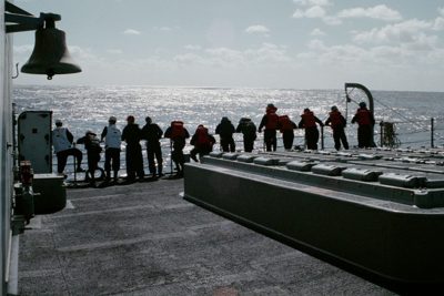 Sailors manning the rails to recover a Sailor overboard