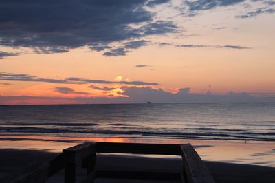 Coastal sunset with vessel silhouetted on the water