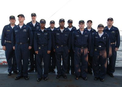 Navy ship's company crew lined up on deck in NWU uniforms